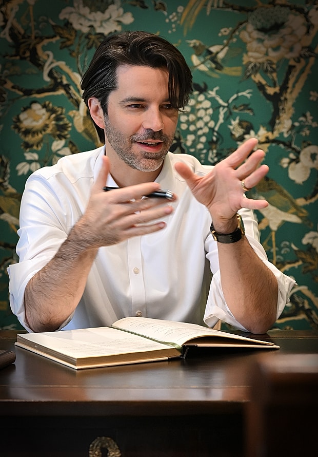 Man gesturing while discussing ideas at a desk.