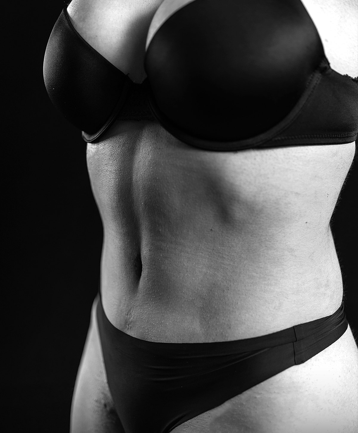 Black and white image of torso wearing lingerie.