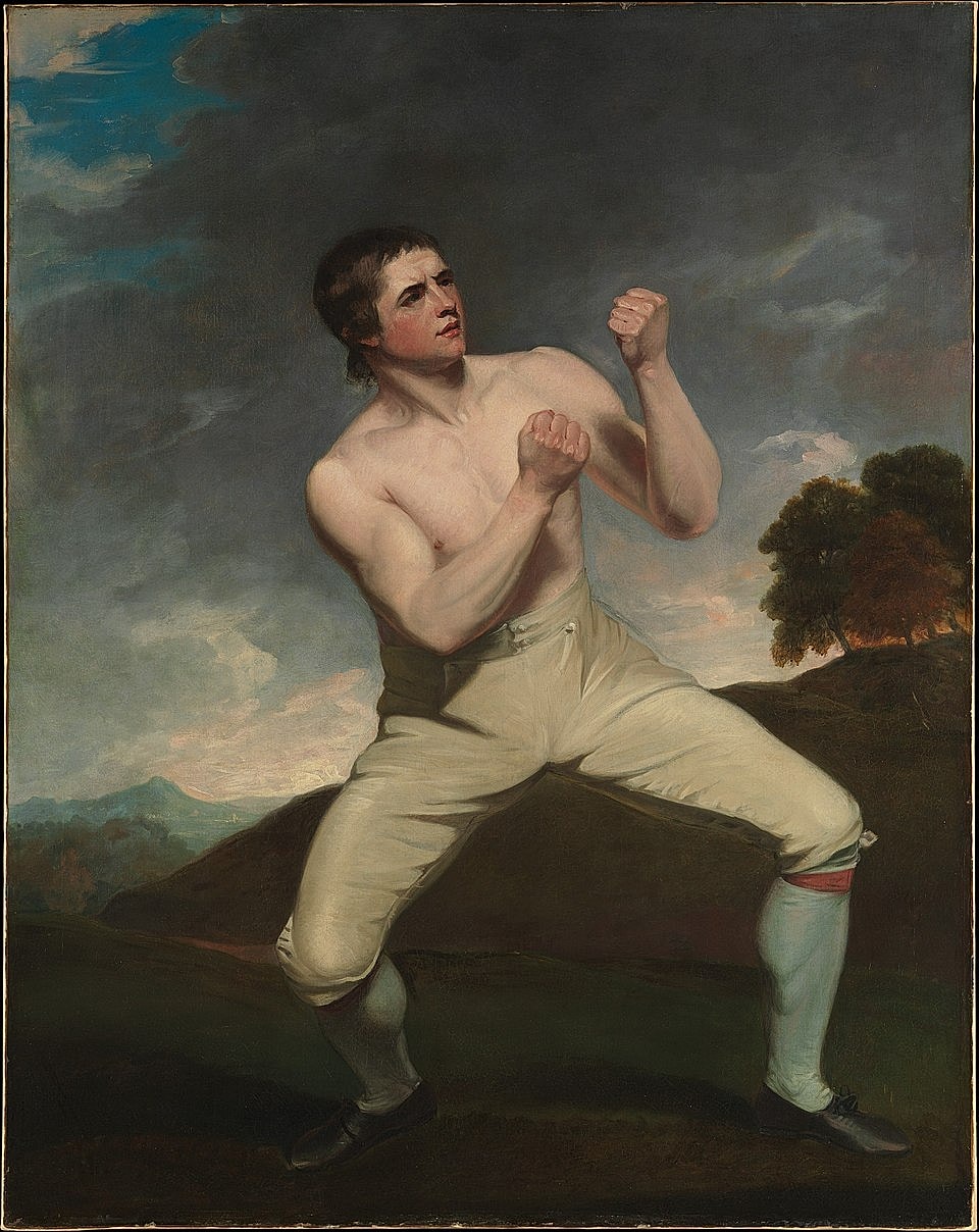 Boxer in a fighting stance against dramatic backdrop.
