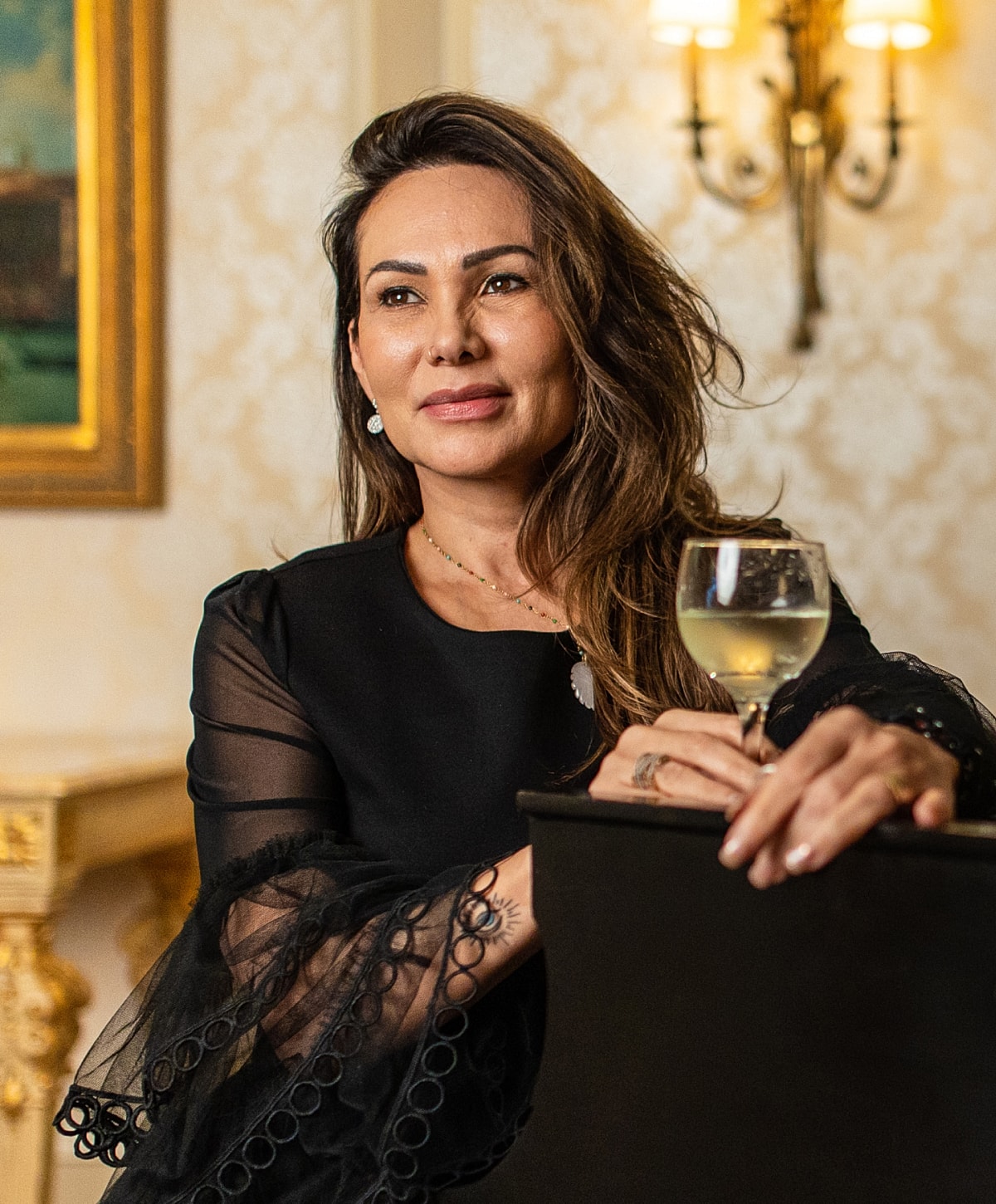 Woman in elegant dress holding a glass.