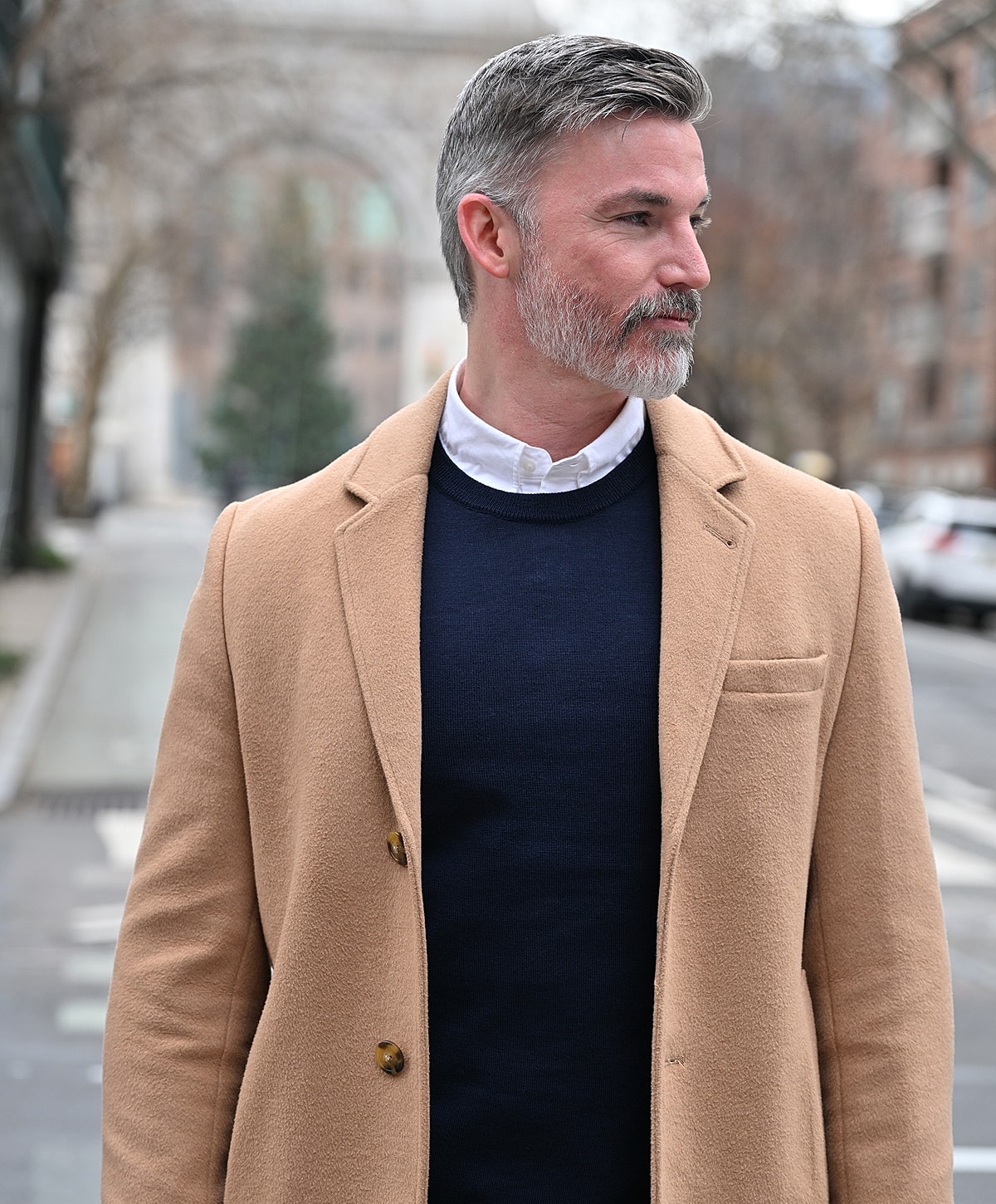 Man in stylish coat on city street.