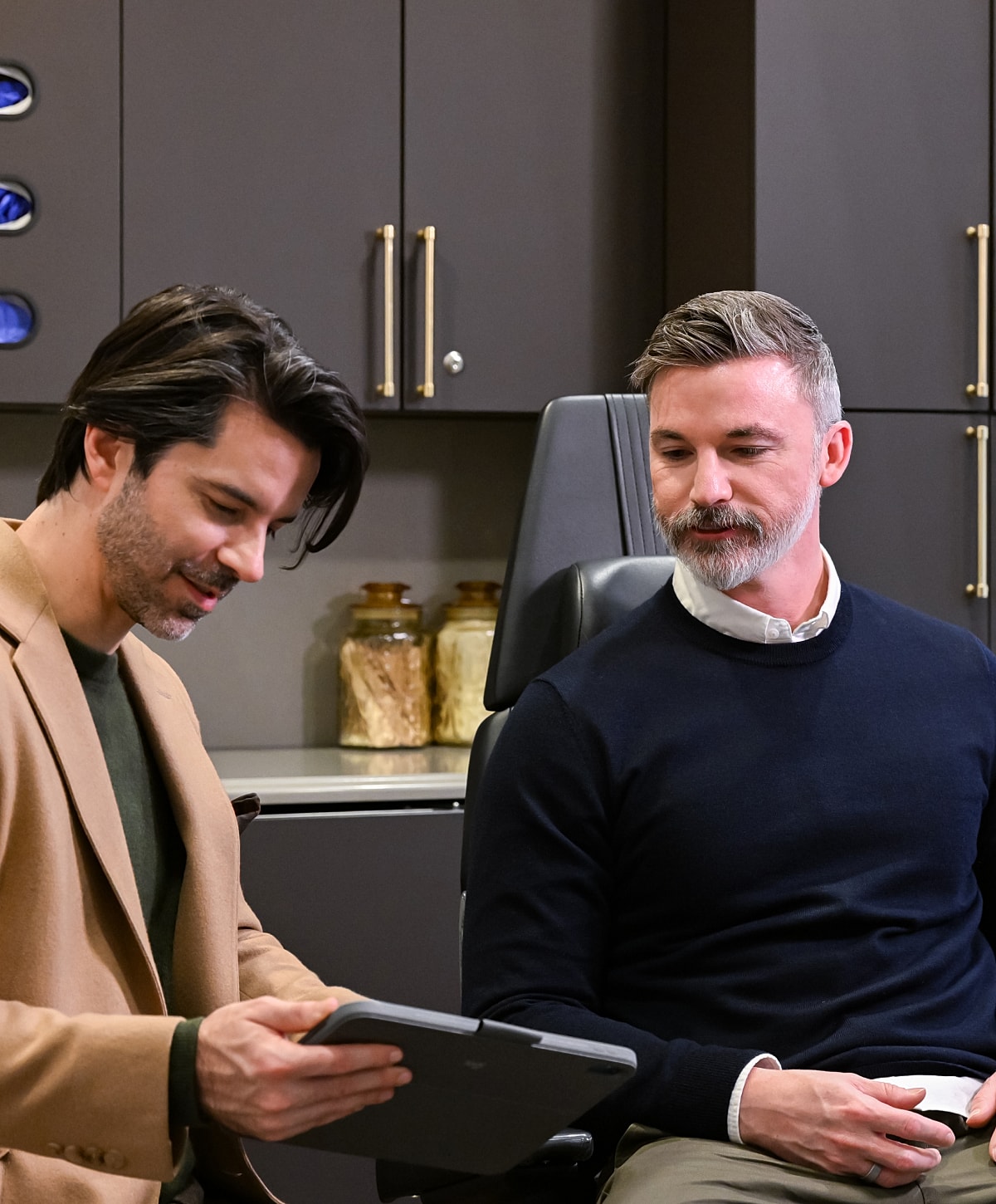 Two men discussing on a tablet in office setting.