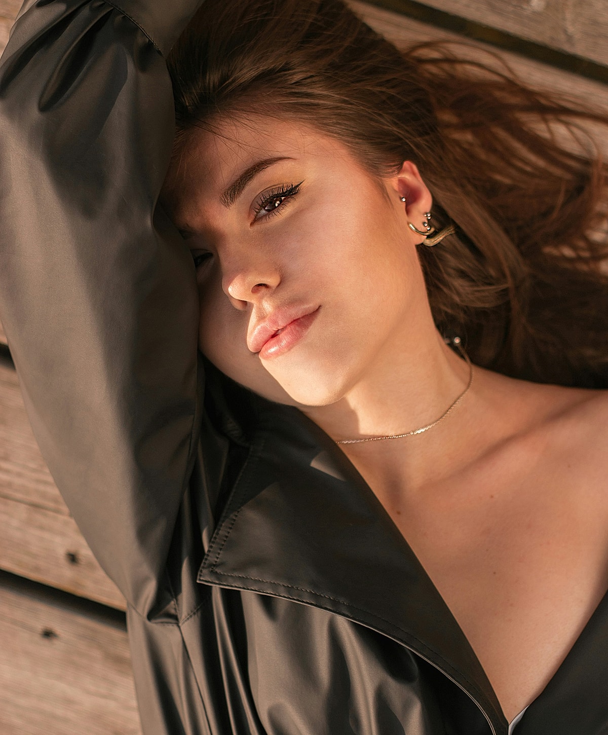 Woman resting with long hair and dark jacket.