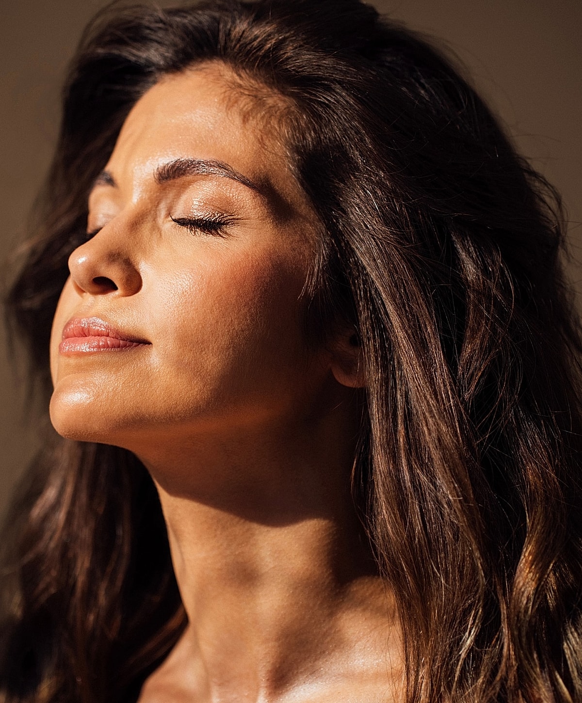 Woman with closed eyes and radiant skin.