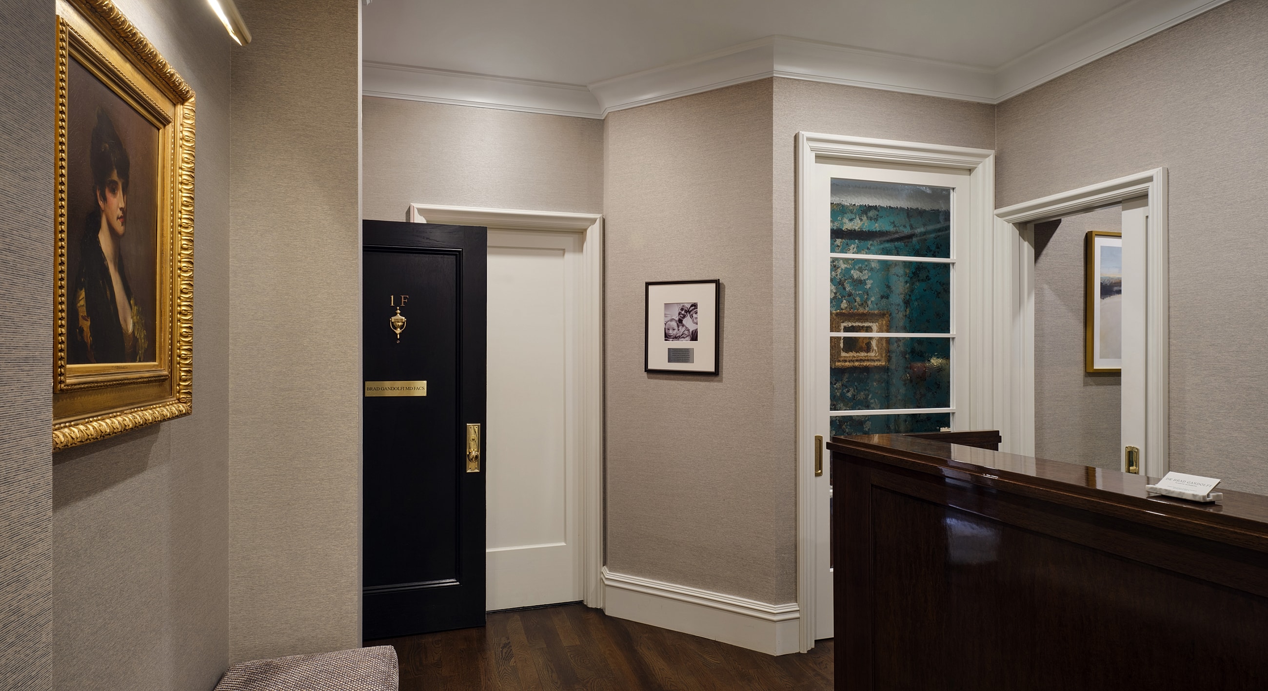 Elegant hallway with artwork and reception desk.