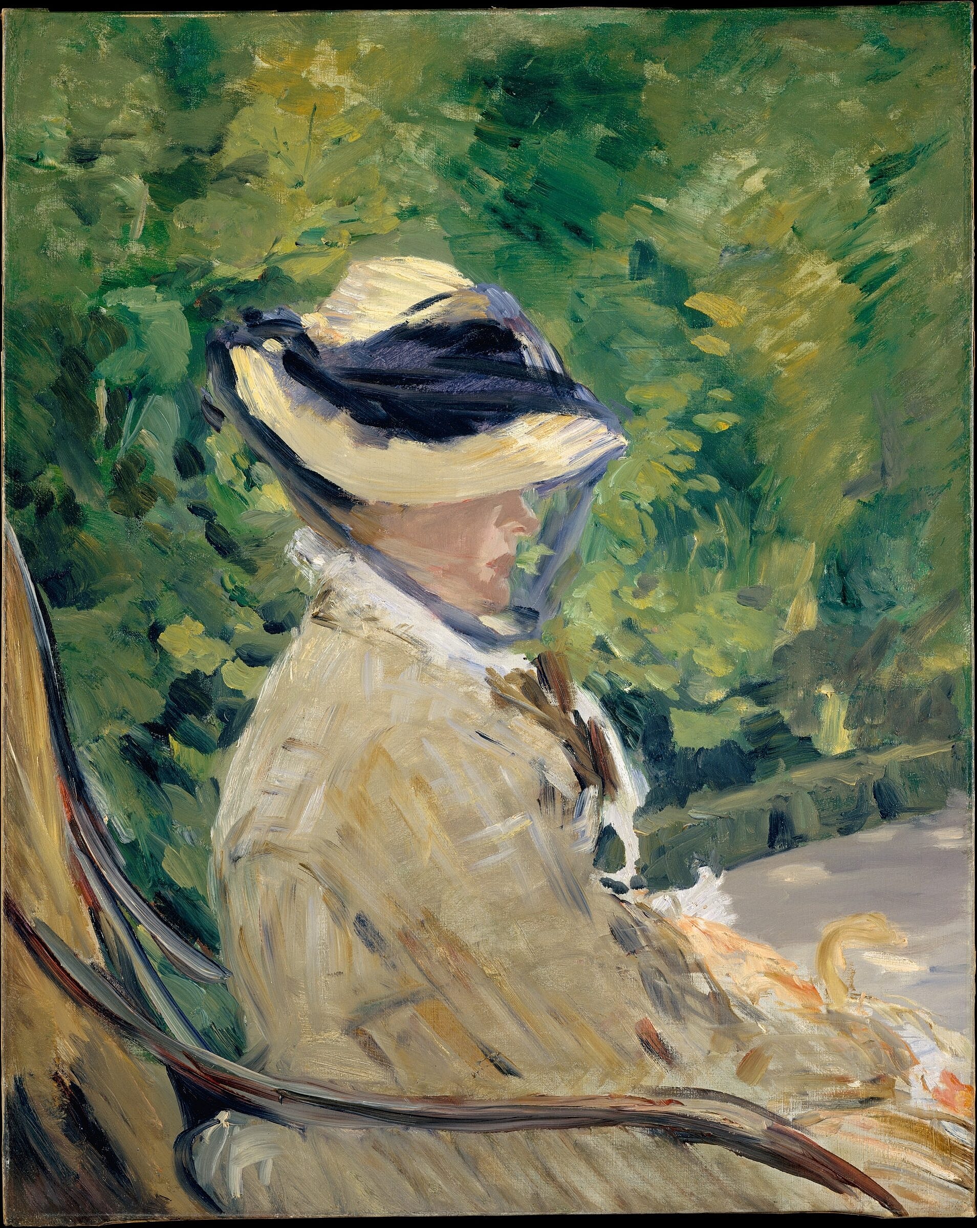 Woman in hat seated amidst greenery.