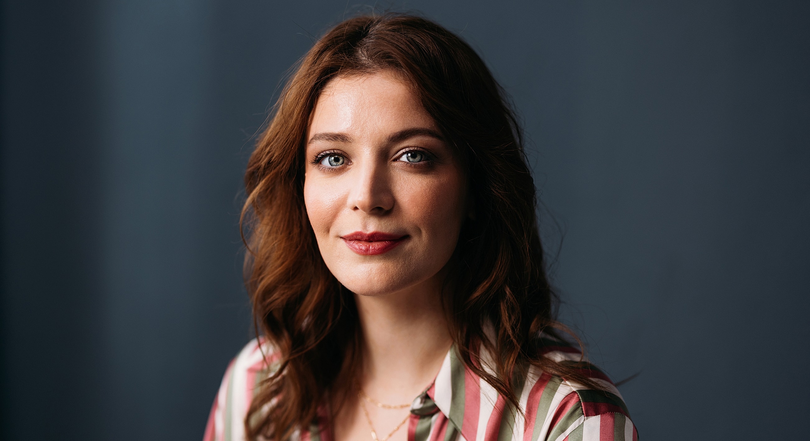 Woman with wavy hair and striped shirt.