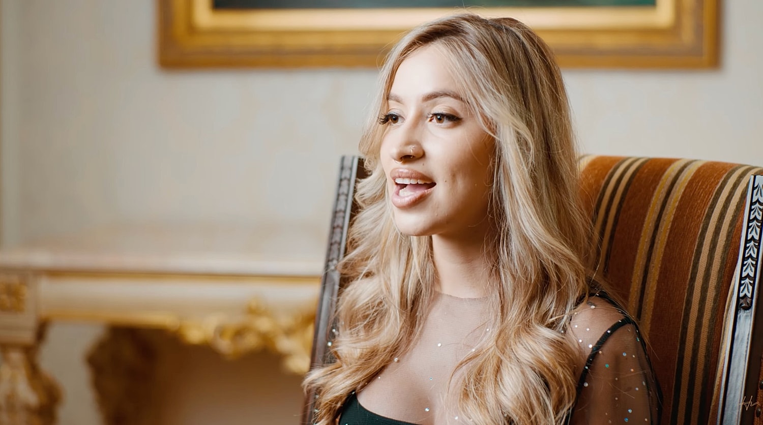 Woman singing while seated in elegant setting